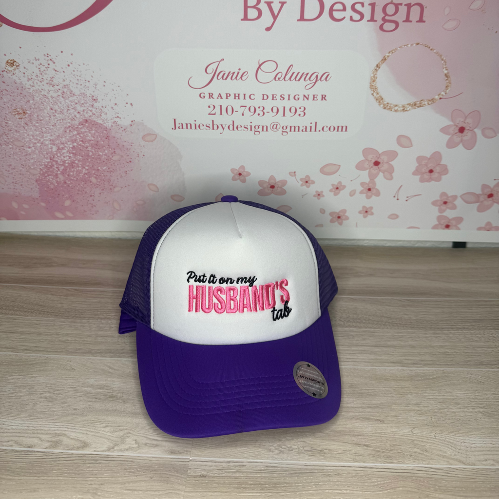 Purple and white cap with text on a wooden surface and floral background