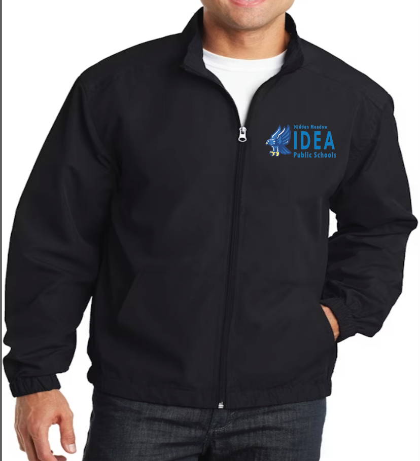 A man wearing a black Port Authority essential jacket with an embroidered logo on the left chest area. The jacket has a zipper and appears to be made of polyester.